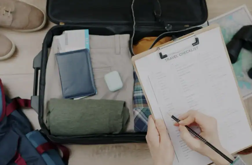 Pessoa organizando itens de viagem em uma mala, checklist de viagem ao lado.