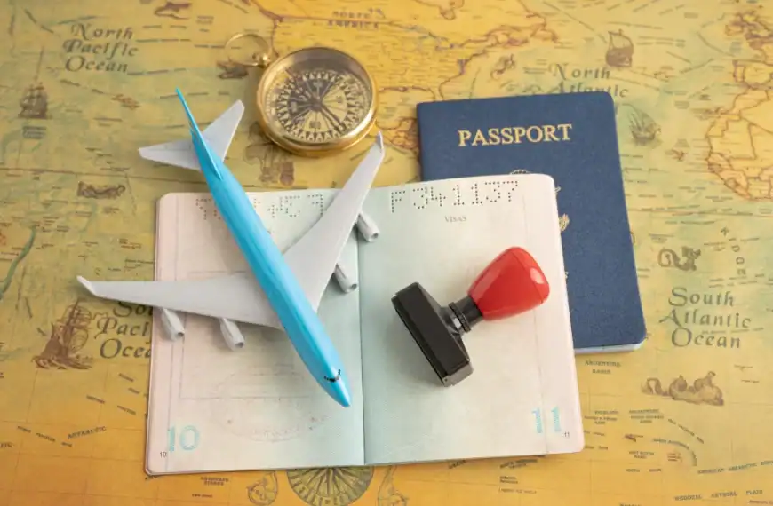Itens de viagem, incluindo passaporte, avião de brinquedo, bússola e carimbo sobre mapa antigo.