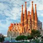 Catedral de Barcelona vista do parque com céu azul e nuvens, destaque na arquitetura gótica.