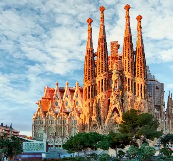 Catedral de Barcelona vista do parque com céu azul e nuvens, destaque na arquitetura gótica.