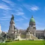 Praça em Buenos Aires com monumentos históricos e edifícios ao fundo.