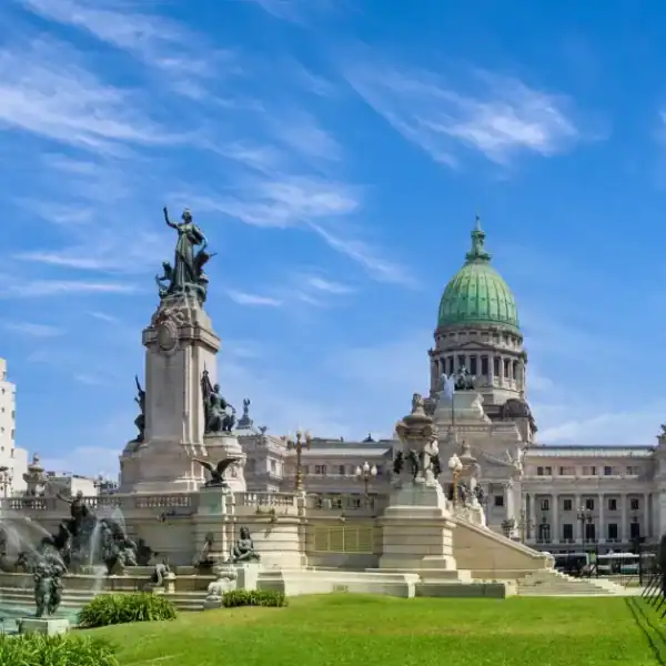 Praça em Buenos Aires com monumentos históricos e edifícios ao fundo.