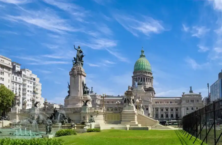 Praça em Buenos Aires com monumentos históricos e edifícios ao fundo.