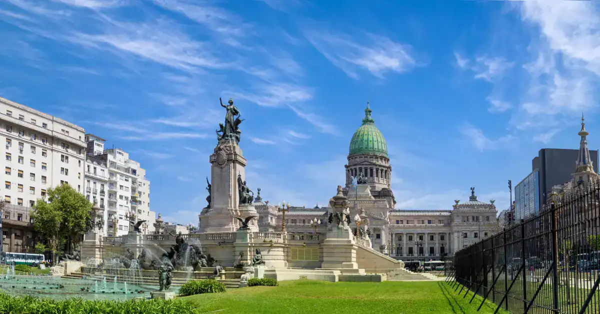 Praça em Buenos Aires com monumentos históricos e edifícios ao fundo.