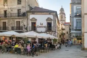 Café ao ar livre na Espanha com pessoas desfrutando de refeições.