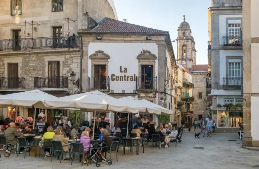 Café ao ar livre na Espanha com pessoas desfrutando de refeições.